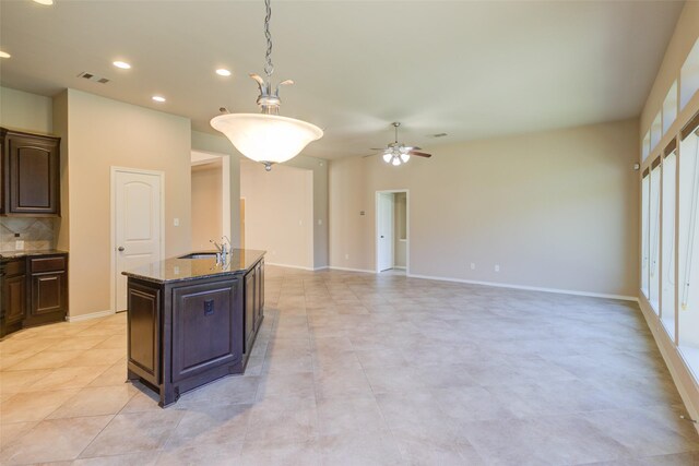 16007 Angler Bend Dr, Houston, TX 77044 - kitchen featuring visible vents, a sink, ceiling fan, a kitchen island with sink, and light stone counters
