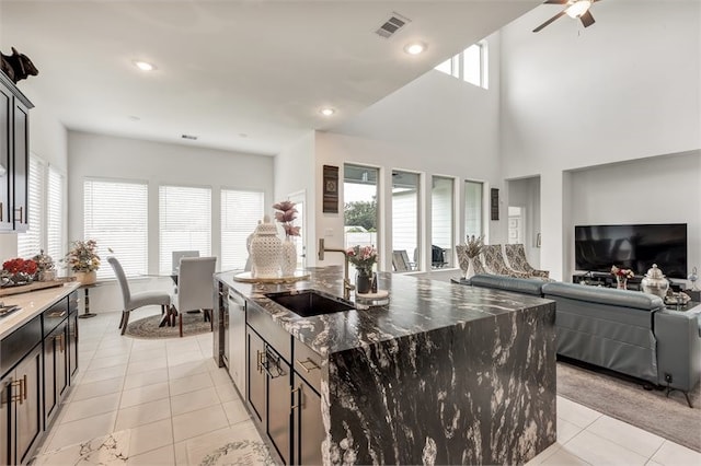 kitchen featuring light tile patterned floors, stainless steel dishwasher, visible vents, a sink, and open floor plan