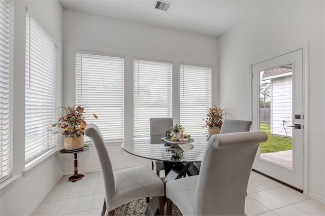 dining space featuring light tile patterned floors, visible vents, and baseboards