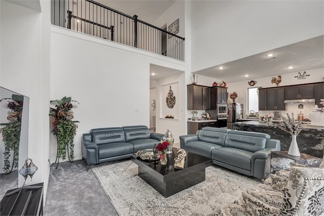 living area featuring carpet floors and a high ceiling