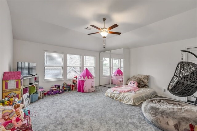 rec room with visible vents, a raised ceiling, a ceiling fan, vaulted ceiling, and carpet flooring