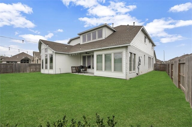 rear view of property featuring a patio, a fenced backyard, ceiling fan, and a lawn