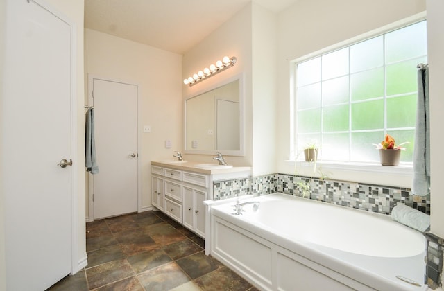 full bathroom with stone finish flooring, a bath, and double vanity