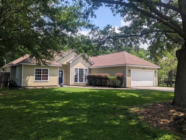 ranch-style house with a garage, a front lawn, concrete driveway, and stucco siding
