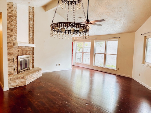 16111 Queensdale Dr, Houston, TX 77082 - unfurnished living room with a brick fireplace, ceiling fan, vaulted ceiling with beams, and hardwood / wood-style floors