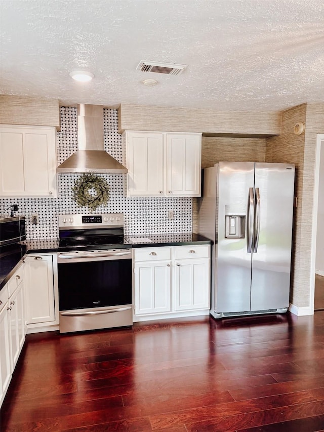 16111 Queensdale Dr, Houston, TX 77082 - kitchen with a textured ceiling, dark countertops, appliances with stainless steel finishes, tasteful backsplash, and wall chimney exhaust hood