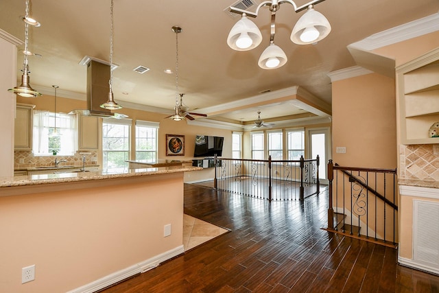kitchen featuring visible vents, dark wood-style floors, crown molding, ceiling fan with notable chandelier, and decorative backsplash