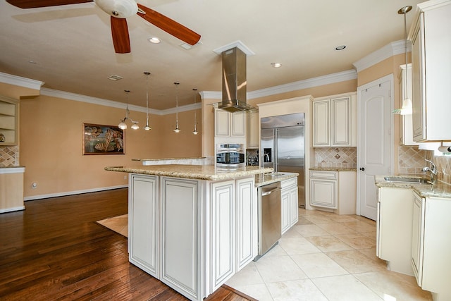 kitchen featuring a sink, a ceiling fan, crown molding, island exhaust hood, and stainless steel appliances