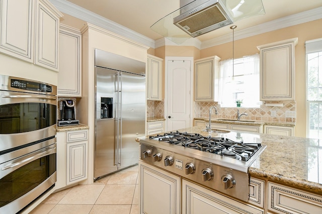 kitchen featuring backsplash, cream cabinets, ornamental molding, and stainless steel appliances