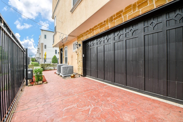 view of patio / terrace with central AC unit and fence