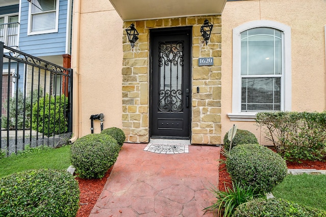 doorway to property with stucco siding and stone siding