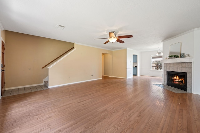 4309 Kingfish Dr, Seabrook, TX 77586 - unfurnished living room featuring ceiling fan, a fireplace, light wood finished floors, baseboards, and crown molding