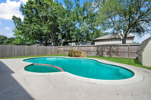 view of swimming pool featuring a pool with connected hot tub, a fenced backyard, and a patio area