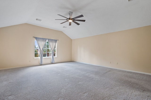carpeted empty room with visible vents, a ceiling fan, and lofted ceiling