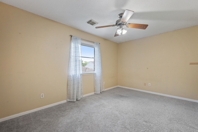 carpeted empty room featuring baseboards, visible vents, and ceiling fan