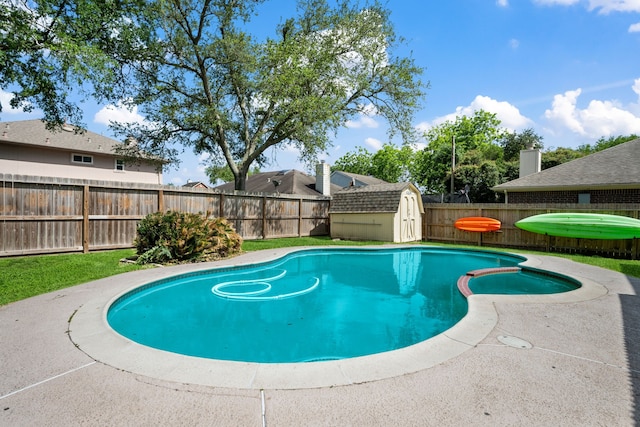 view of swimming pool with a fenced backyard, a shed, a pool with connected hot tub, and an outdoor structure