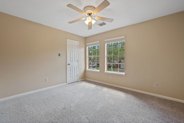 unfurnished room with baseboards, visible vents, light carpet, and ceiling fan