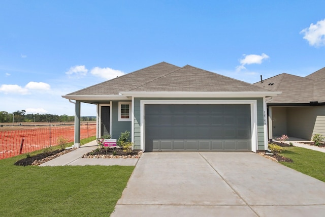 single story home featuring roof with shingles, concrete driveway, fence, a garage, and a front yard