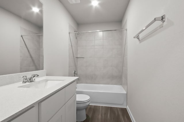 full bathroom featuring wood finished floors, toilet, vanity, tub / shower combination, and baseboards