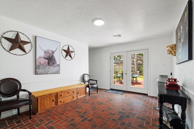 9203 Mauna Loa Ln, Houston, TX 77040 - living area featuring brick floor, french doors, baseboards, and visible vents