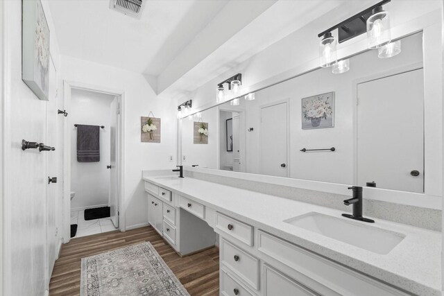 9203 Mauna Loa Ln, Houston, TX 77040 - bathroom with a sink, visible vents, double vanity, and wood finished floors