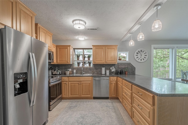 101 Tony Ln, Huntsville, TX 77320 - kitchen with a sink, visible vents, a peninsula, dark countertops, and appliances with stainless steel finishes