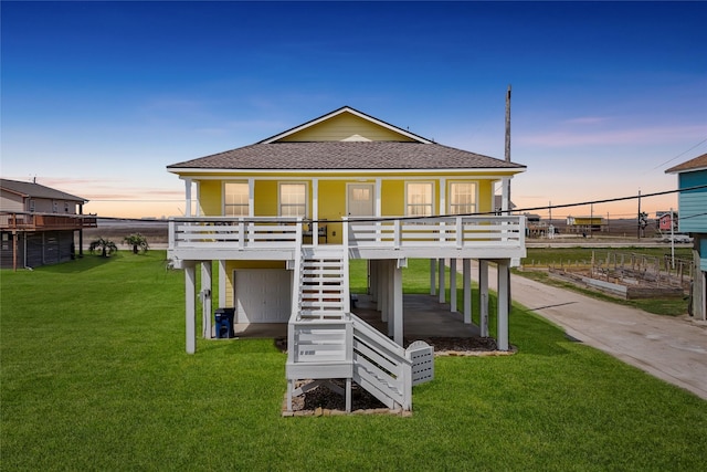 1014 Blue Water Hwy, Surfside Beach, TX 77541 - rear view of house featuring roof with shingles, a yard, covered porch, and stairway