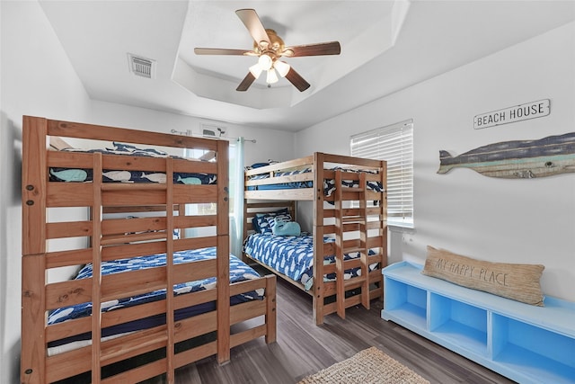 1014 Blue Water Hwy, Surfside Beach, TX 77541 - bedroom featuring visible vents, a tray ceiling, multiple windows, and wood finished floors