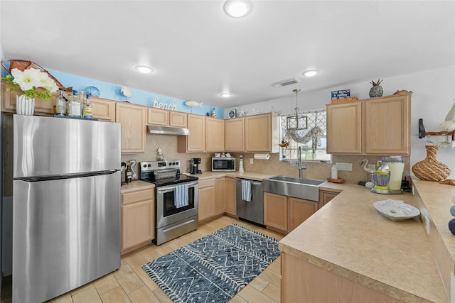 1014 Blue Water Hwy, Surfside Beach, TX 77541 - kitchen with light brown cabinets, under cabinet range hood, visible vents, stainless steel appliances, and a sink