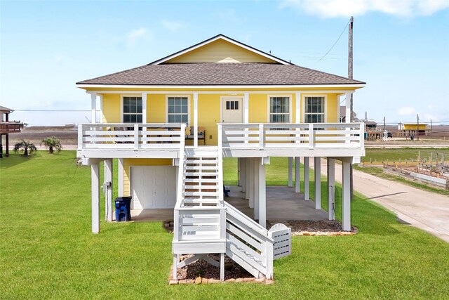1014 Blue Water Hwy, Surfside Beach, TX 77541 - coastal inspired home featuring a front yard, a shingled roof, a carport, a porch, and stairway