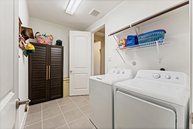 137 Gray Vervain Ct, Montgomery, TX 77316 - laundry area featuring washing machine and dryer, visible vents, laundry area, and light tile patterned floors