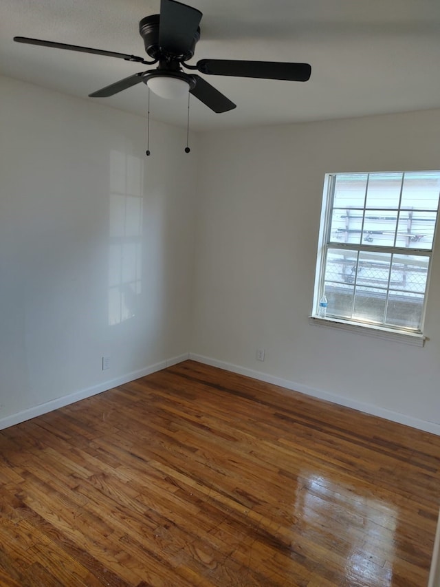 spare room with ceiling fan, baseboards, and wood finished floors