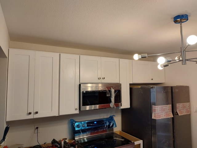 kitchen with white cabinets and appliances with stainless steel finishes