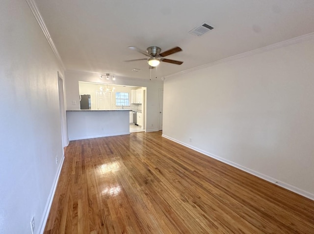 11026 Catamore St, Houston, TX 77076 - unfurnished living room featuring wood finished floors, ornamental molding, a ceiling fan, and baseboards
