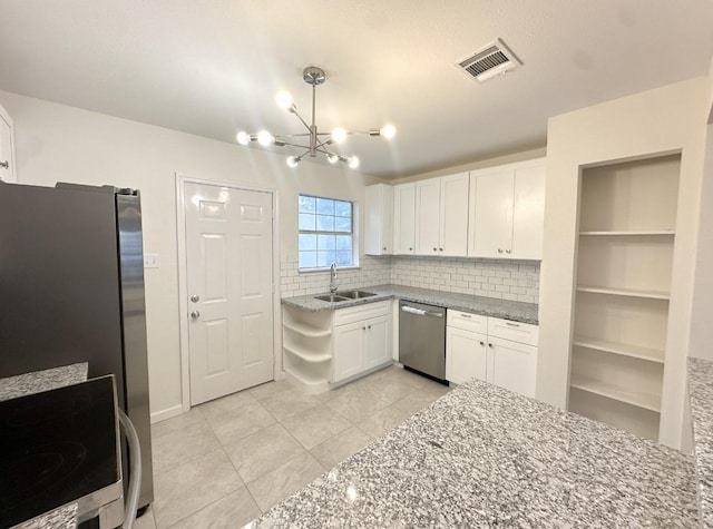 11026 Catamore St, Houston, TX 77076 - kitchen featuring stainless steel appliances, a sink, a chandelier, white cabinetry, and light stone countertops