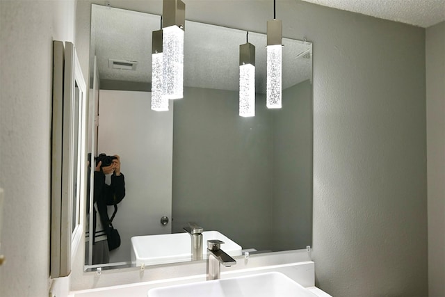 bathroom with a textured ceiling and a sink