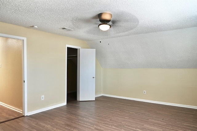 additional living space featuring baseboards, wood finished floors, a textured ceiling, and visible vents