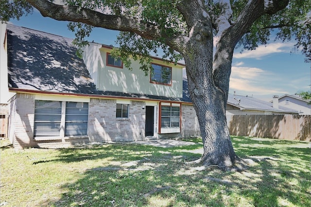 back of property featuring fence and a yard