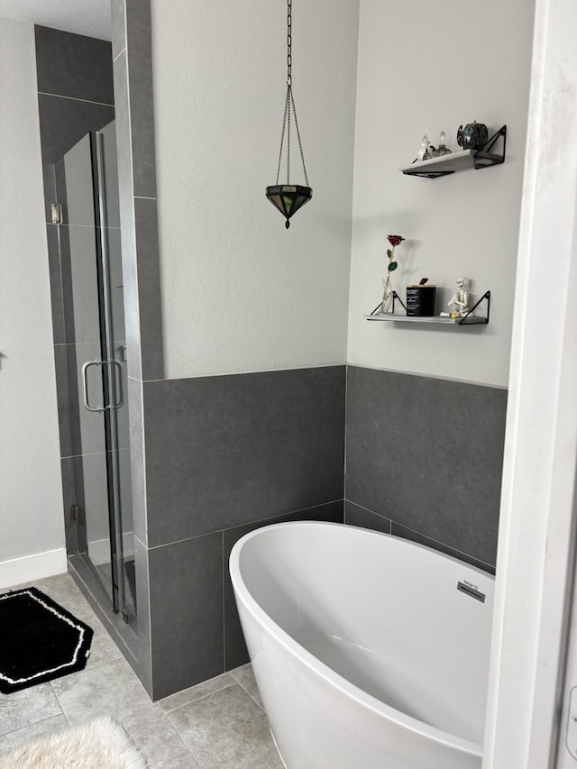 15888 Chestnut Dr, Montgomery, TX 77356 - full bath with tile patterned flooring, tile walls, a freestanding tub, and a stall shower