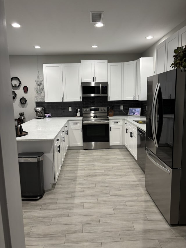 15888 Chestnut Dr, Montgomery, TX 77356 - kitchen featuring decorative backsplash, white cabinetry, visible vents, and stainless steel appliances