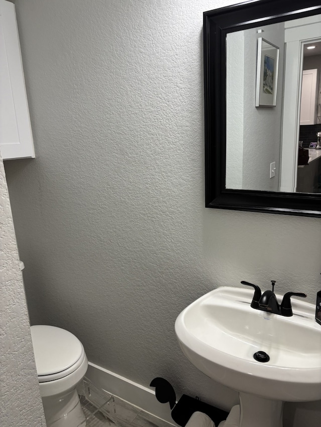 15888 Chestnut Dr, Montgomery, TX 77356 - half bath featuring a textured wall, marble finish floor, a sink, and toilet