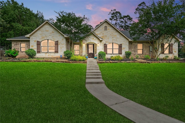 1858 Stoney Brook Ct, Conroe, TX 77304 - french country inspired facade with a lawn, stone siding, and roof with shingles