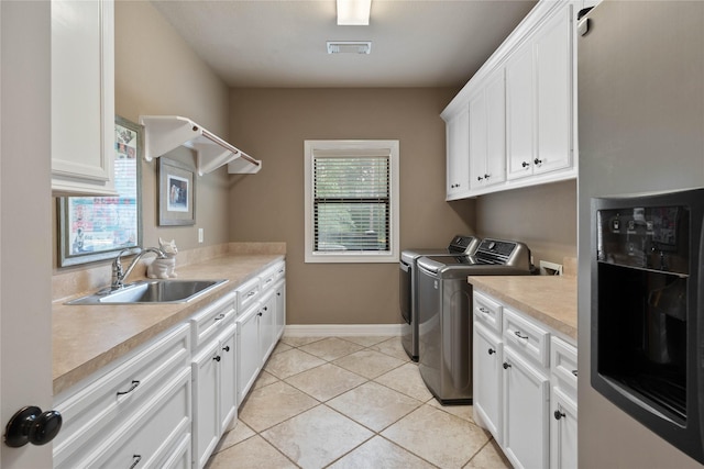1858 Stoney Brook Ct, Conroe, TX 77304 - laundry area with cabinet space, washer and dryer, light tile patterned floors, and baseboards