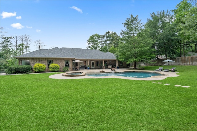 1858 Stoney Brook Ct, Conroe, TX 77304 - back of property featuring a patio, a pool with connected hot tub, brick siding, and roof with shingles
