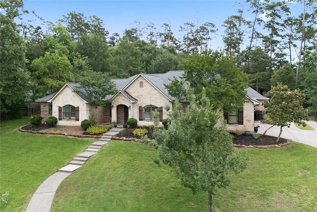1858 Stoney Brook Ct, Conroe, TX 77304 - french country inspired facade with stone siding, a front lawn, and a shingled roof