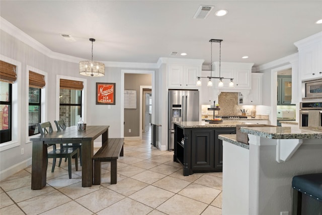 1858 Stoney Brook Ct, Conroe, TX 77304 - kitchen featuring appliances with stainless steel finishes, a chandelier, backsplash, a center island, and light tile patterned floors