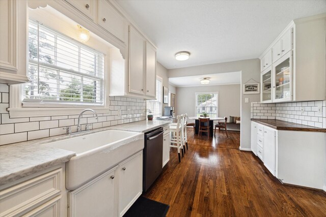 6402 Brookside Dr, Houston, TX 77023 - kitchen featuring dishwasher, dark wood finished floors, a sink, decorative backsplash, and white cabinetry