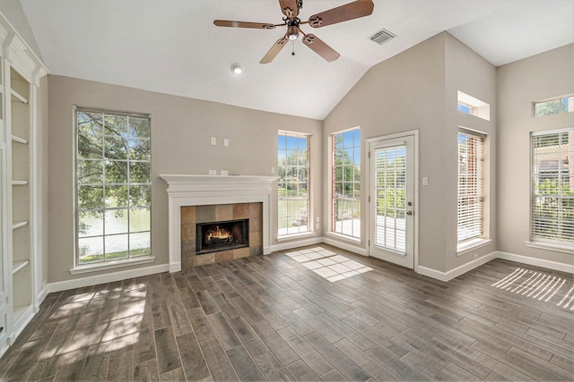 unfurnished living room featuring baseboards, a ceiling fan, dark wood-type flooring, visible vents, and a healthy amount of sunlight