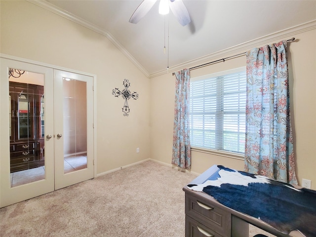 carpeted bedroom featuring lofted ceiling, baseboards, french doors, crown molding, and ceiling fan
