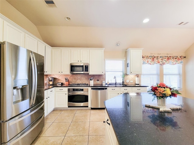 kitchen with tasteful backsplash, visible vents, a sink, stainless steel appliances, and light tile patterned flooring